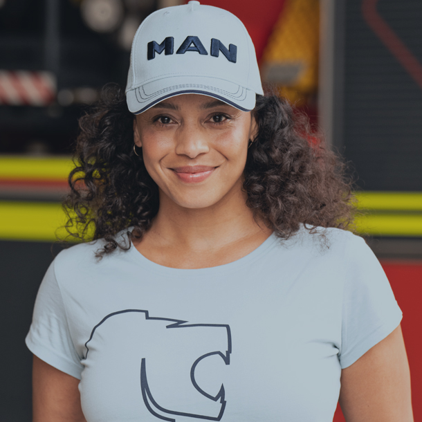 Frau mit MAN-Basecap und T-Shirt im MAN-Design, präsentiert Lifestyle-Bekleidung aus dem MAN Merchandising Shop.